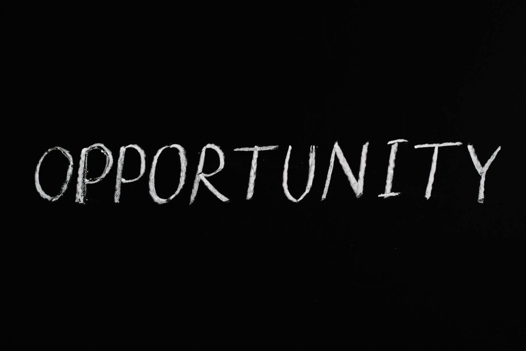 Word 'Opportunity' written in chalk on a black chalkboard, symbolizing new possibilities.