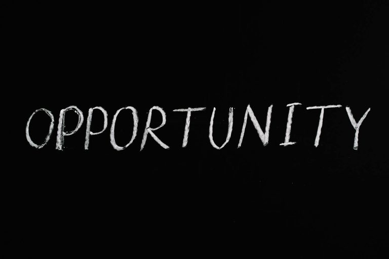 Word 'Opportunity' written in chalk on a black chalkboard, symbolizing new possibilities.