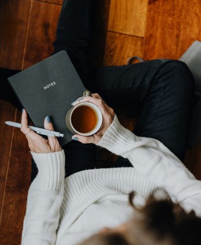 Top view of woman with notebook and coffee Top view of woman with notebook and coffee