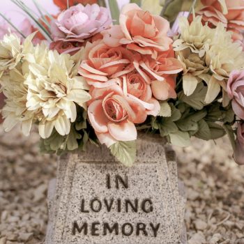 pink and white flowers on gray concrete tomb